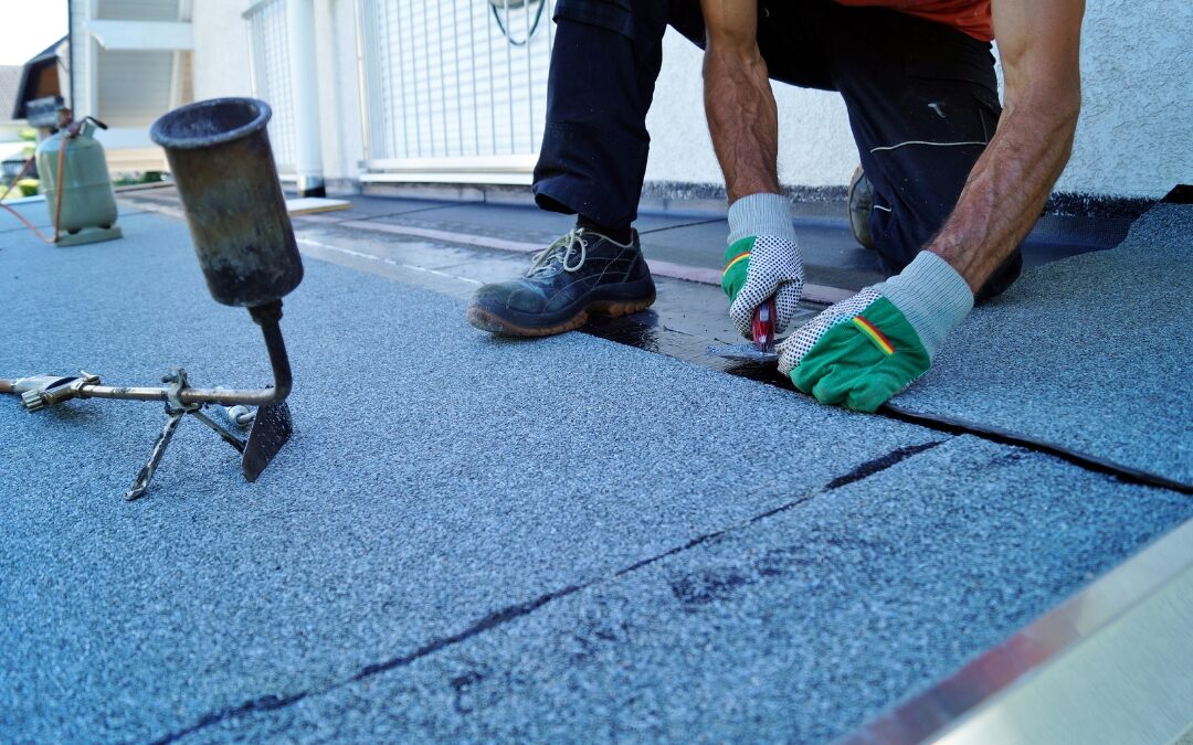 Operario de la construcción instalando una membrana impermeabilizante.